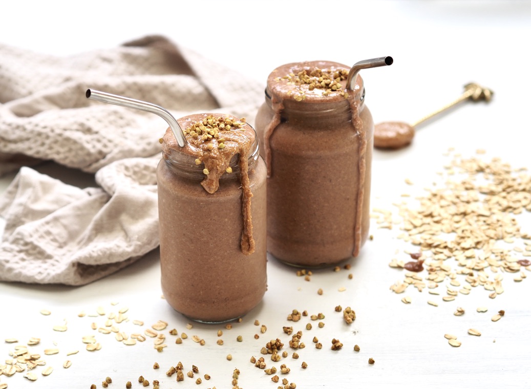 Two chocolate smoothies that keep you full in jars on a kitchen bench